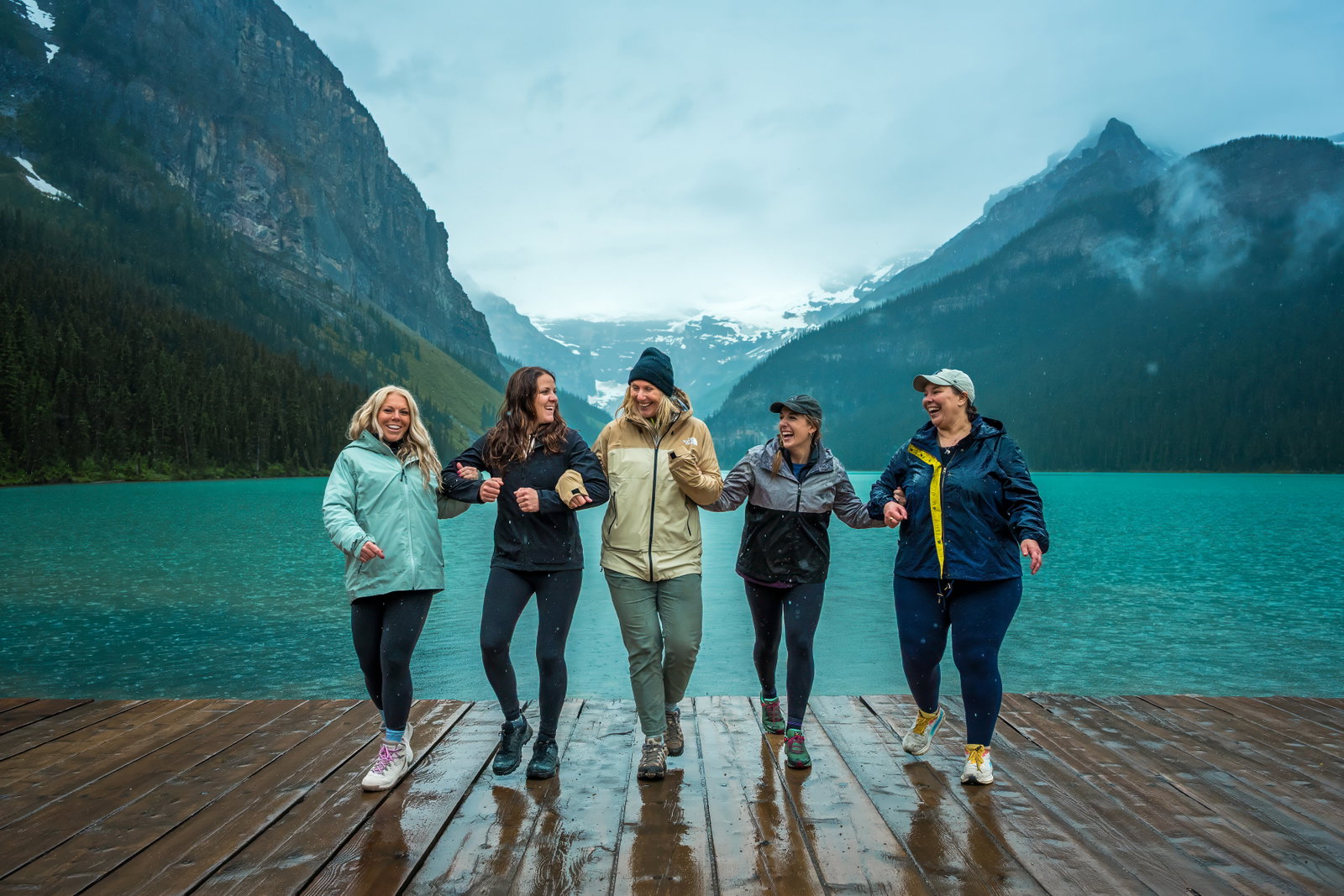 A group of girls enjoying the view of Lake Louise in Banff National Park on a rainy day.