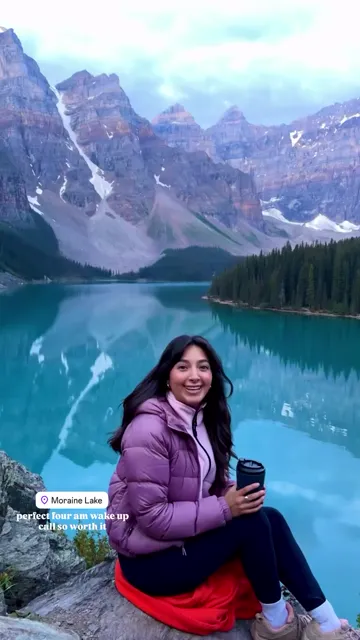 Woman in a purple jacket sitting above Moraine Lake and the Valley of the Ten Peaks