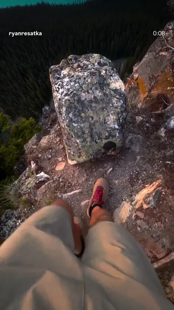 Hiker's boots resting above a steep rocky mountain viewpoint