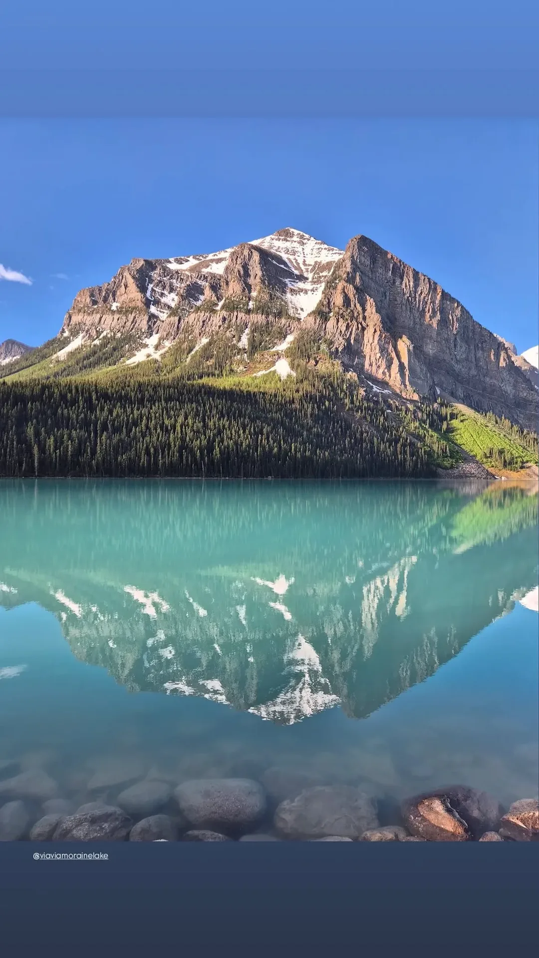 Emerald Lake reflecting a sunlit mountain and evergreen forest