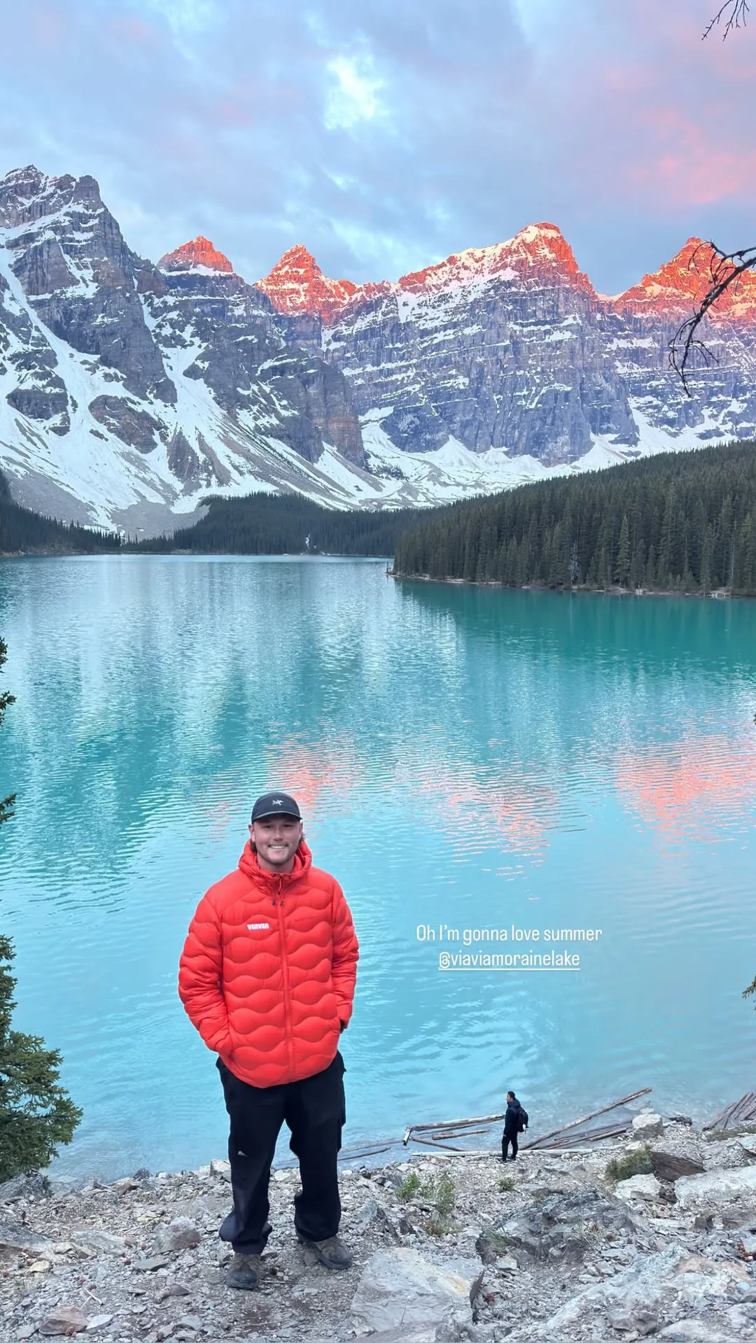 Guest in a red jacket standing at the shore of Moraine Lake