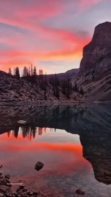 Red sunrise sky reflected in a calm mountain lake