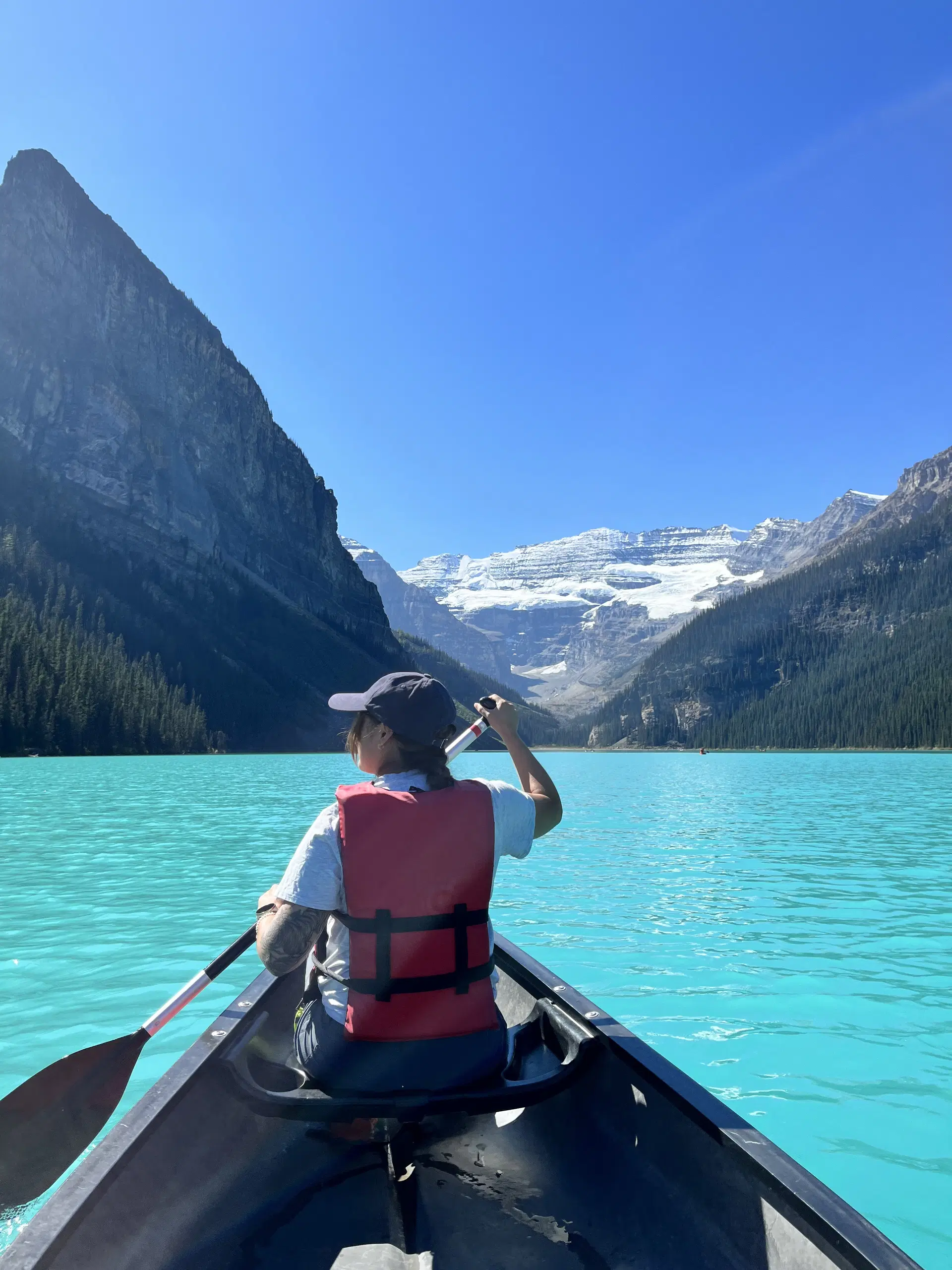 Woman canoeing on Lake Louise in Banff National Park.