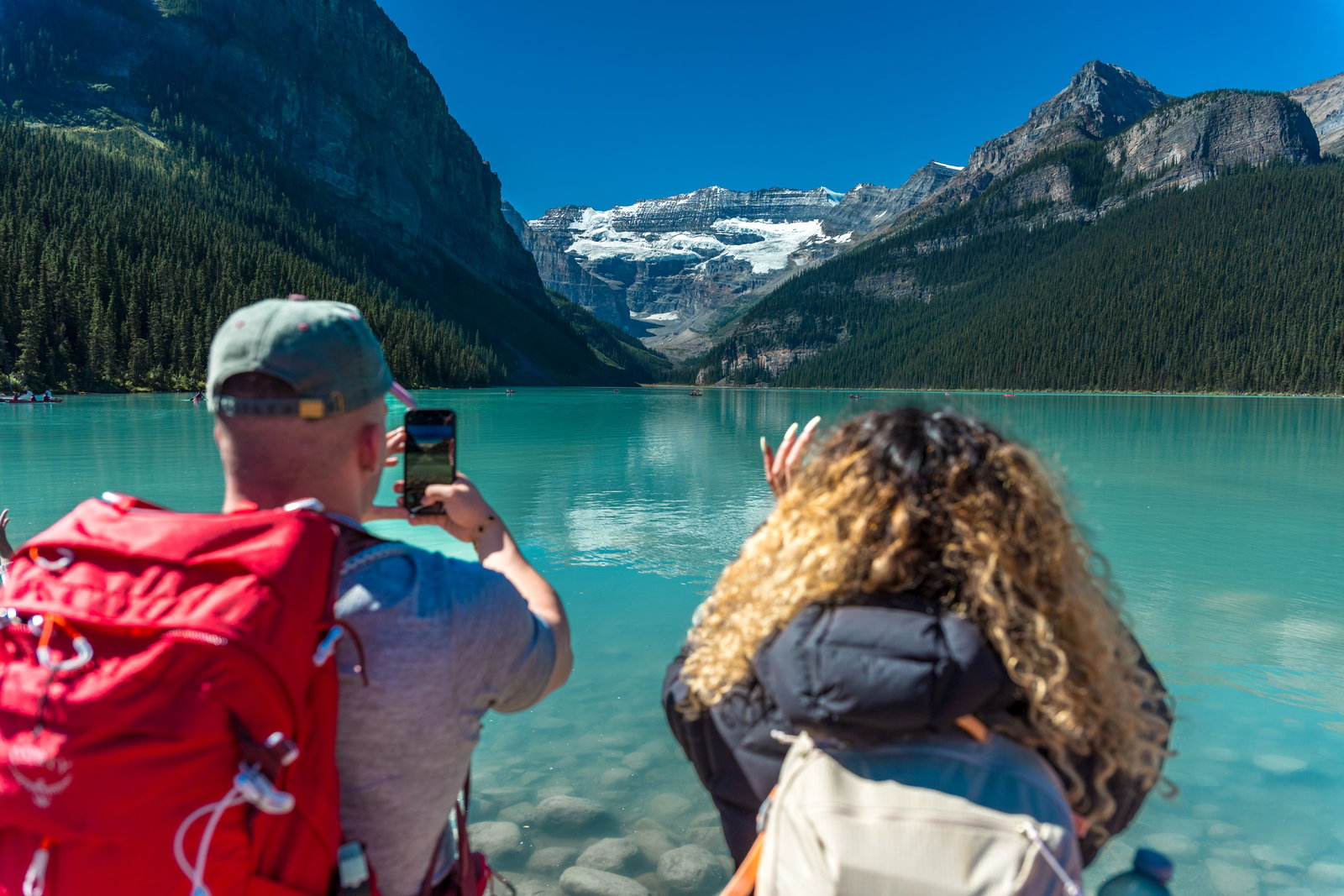 A couple taking photos of Lake Louise