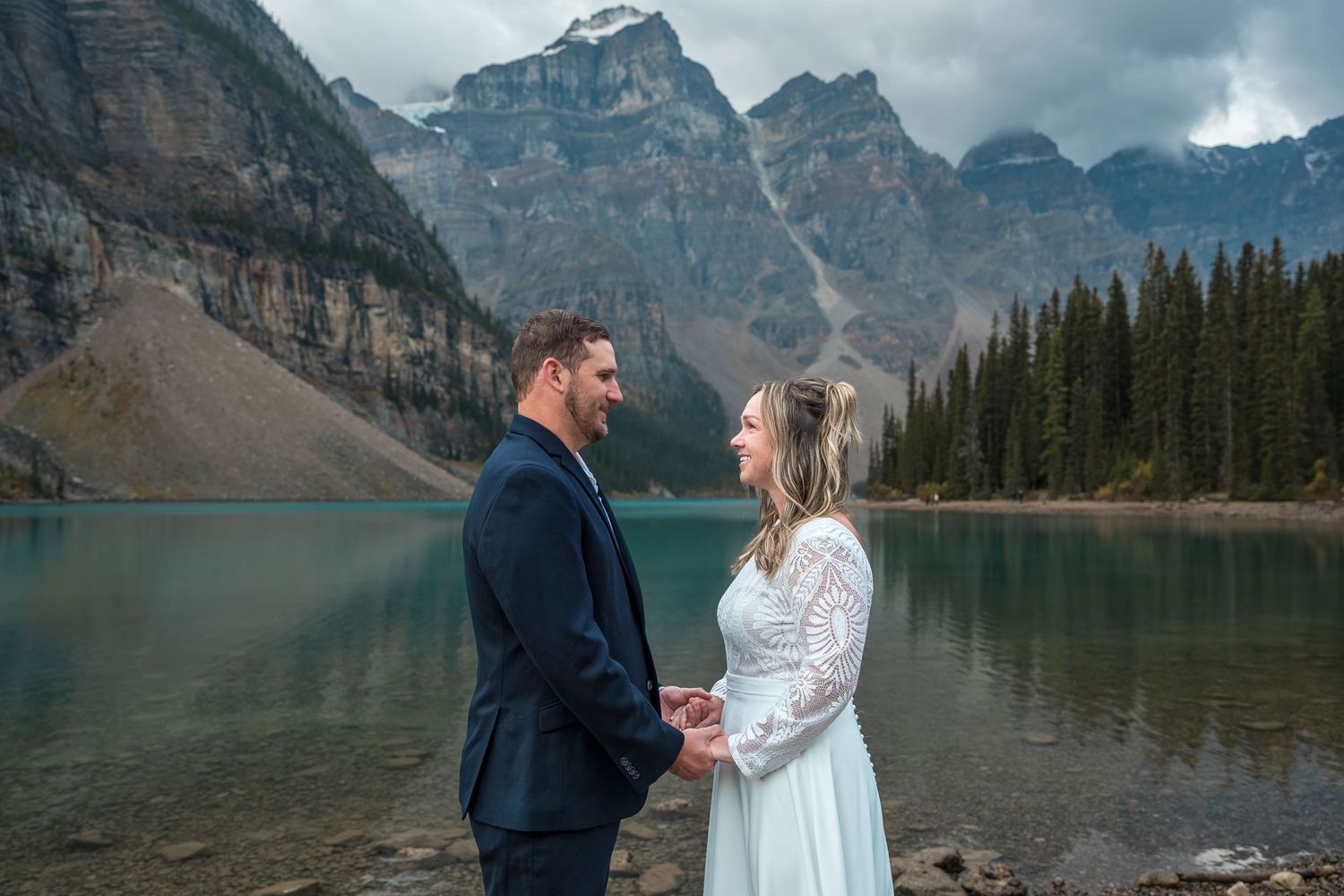 A couple enjoying the view of Moraine Lake in Banff National Park at the lakeshore.