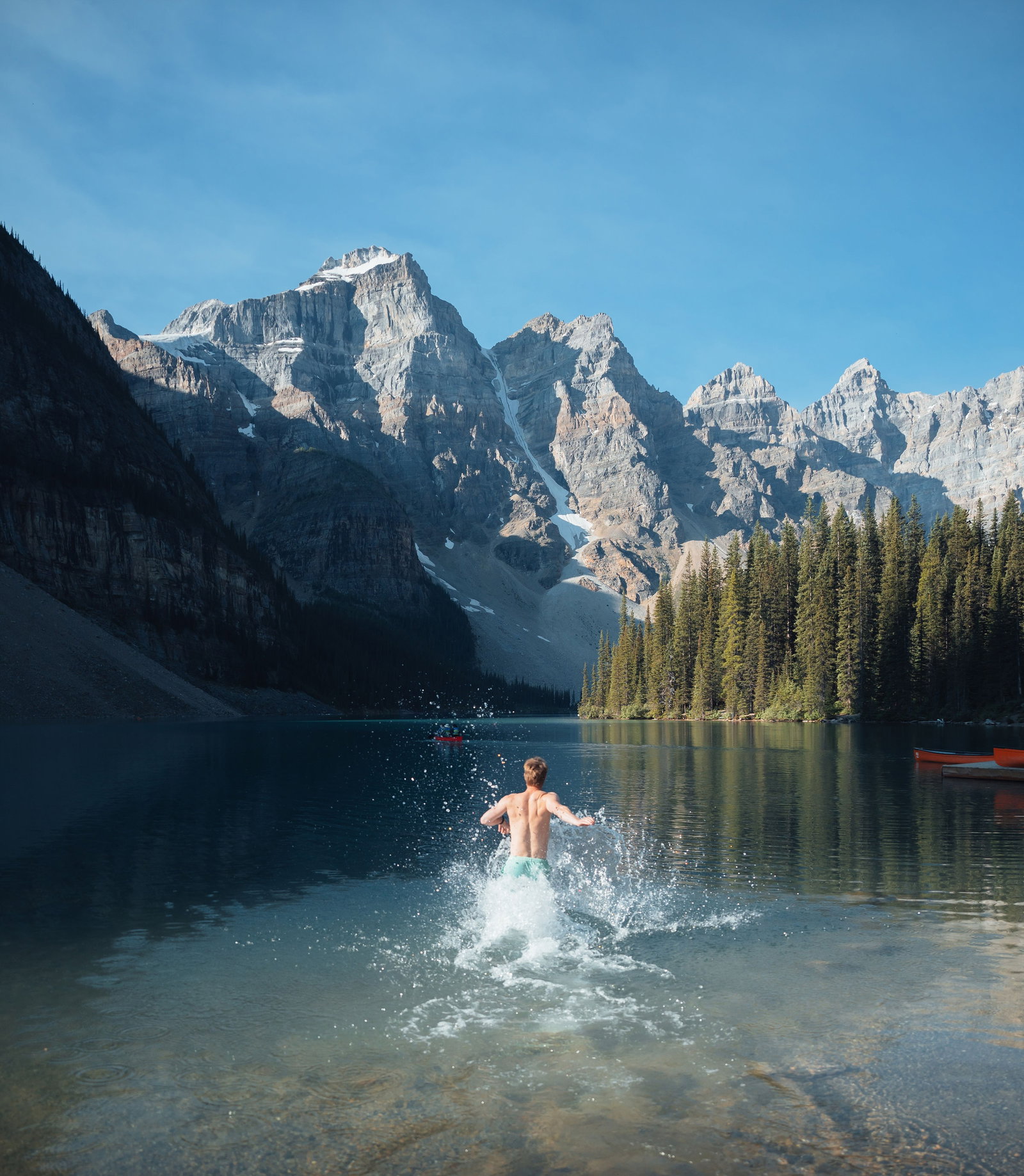 Man jumping into Moraine Lake in Banff National Park.