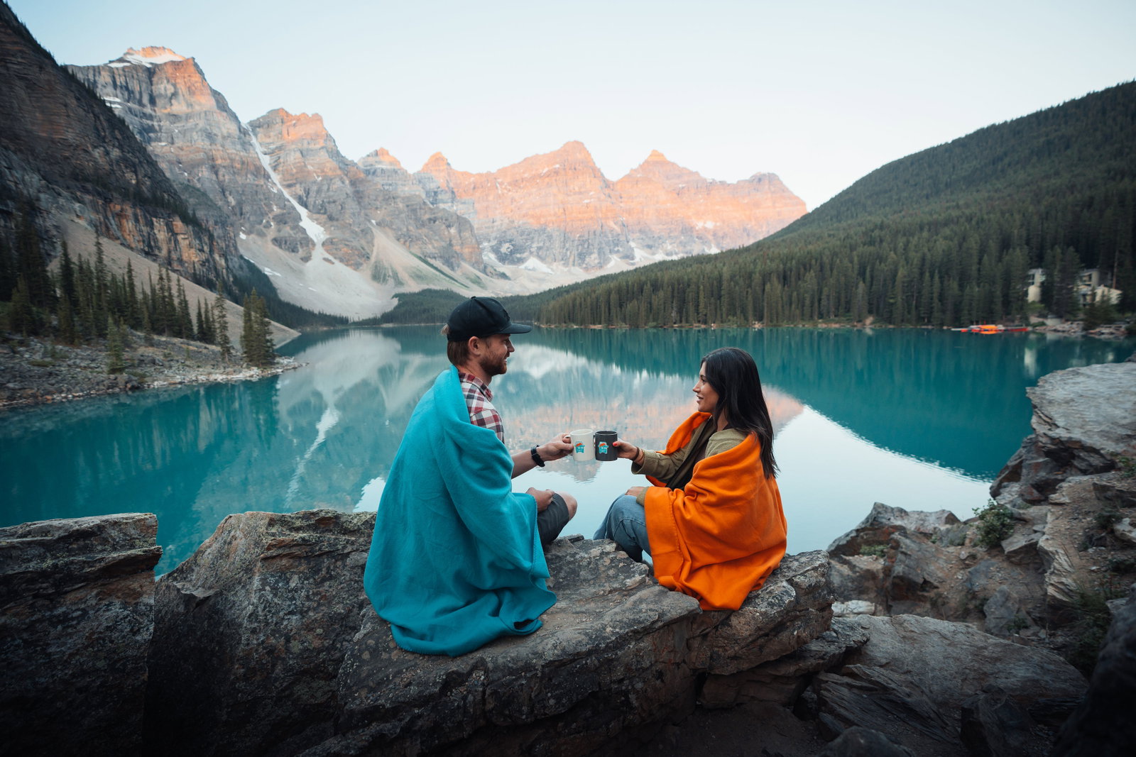 Friends celebrating sunrise at Moraine Lake with coffee
