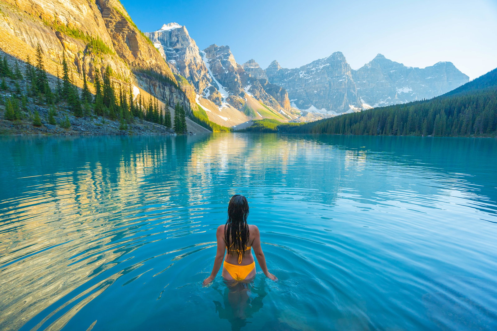 A woman takes a dip in Moraine Lake in Banff National Park.
