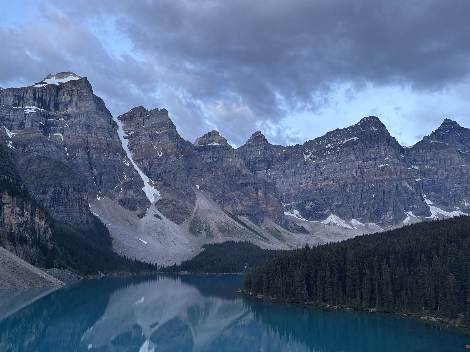 Moraine Lake reflecting the Valley of the Ten Peaks beneath morning clouds