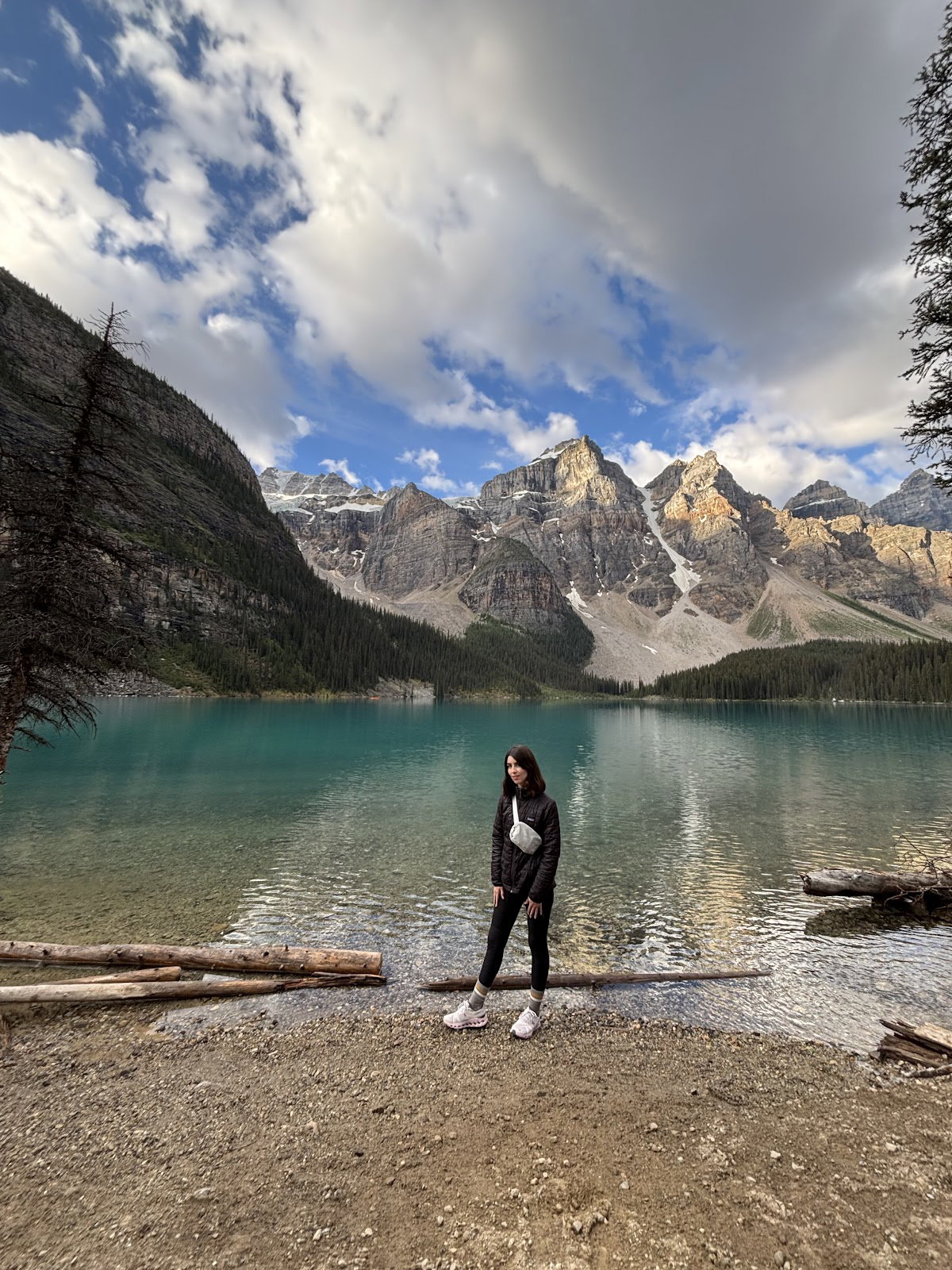 Via Via guest standing beside Moraine Lake with the Valley of the Ten Peaks behind her